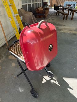 Red Charcoal Grill on Wheels and 2 camping chairs