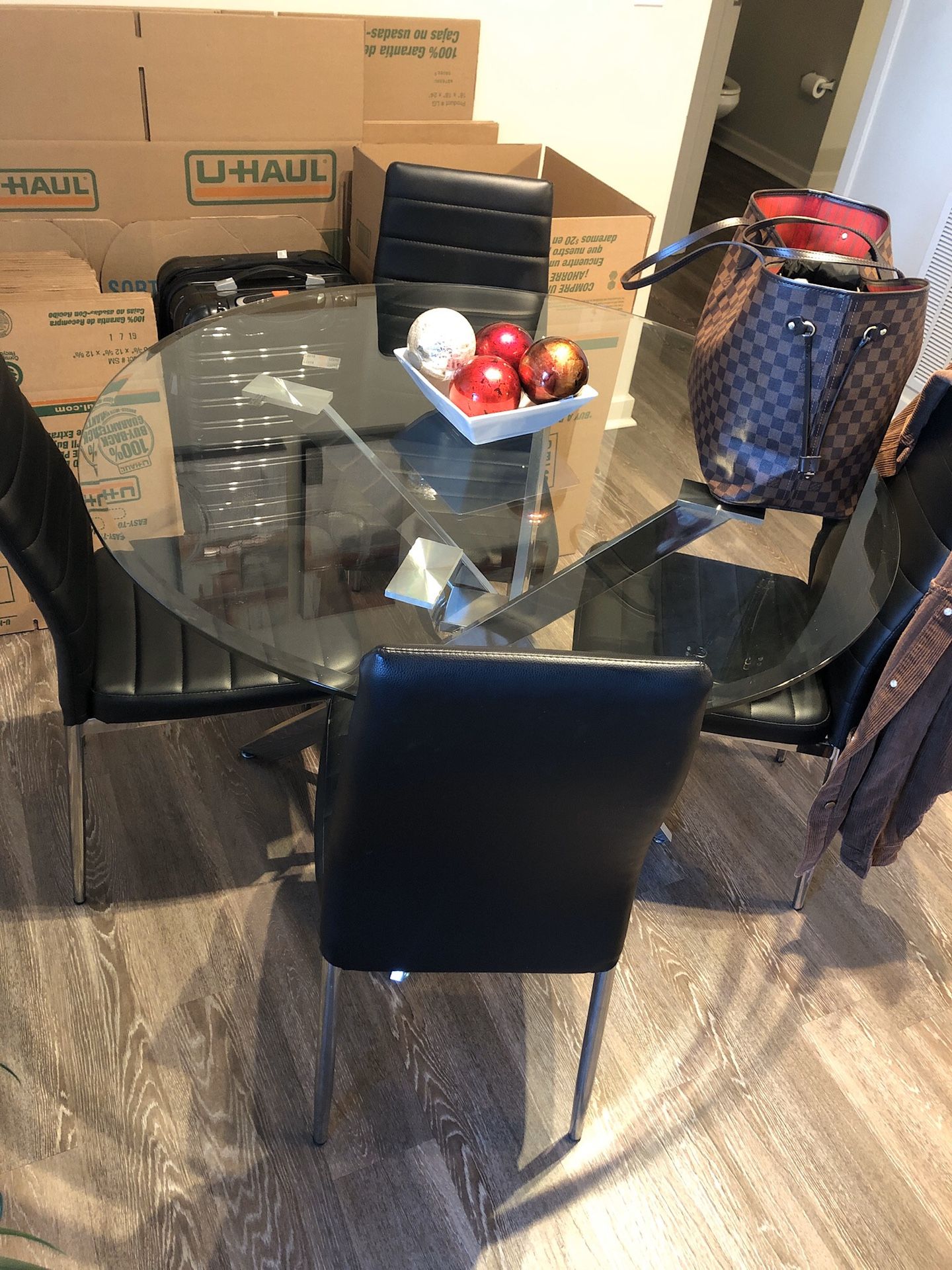 Glass dining room table with 4 black chairs