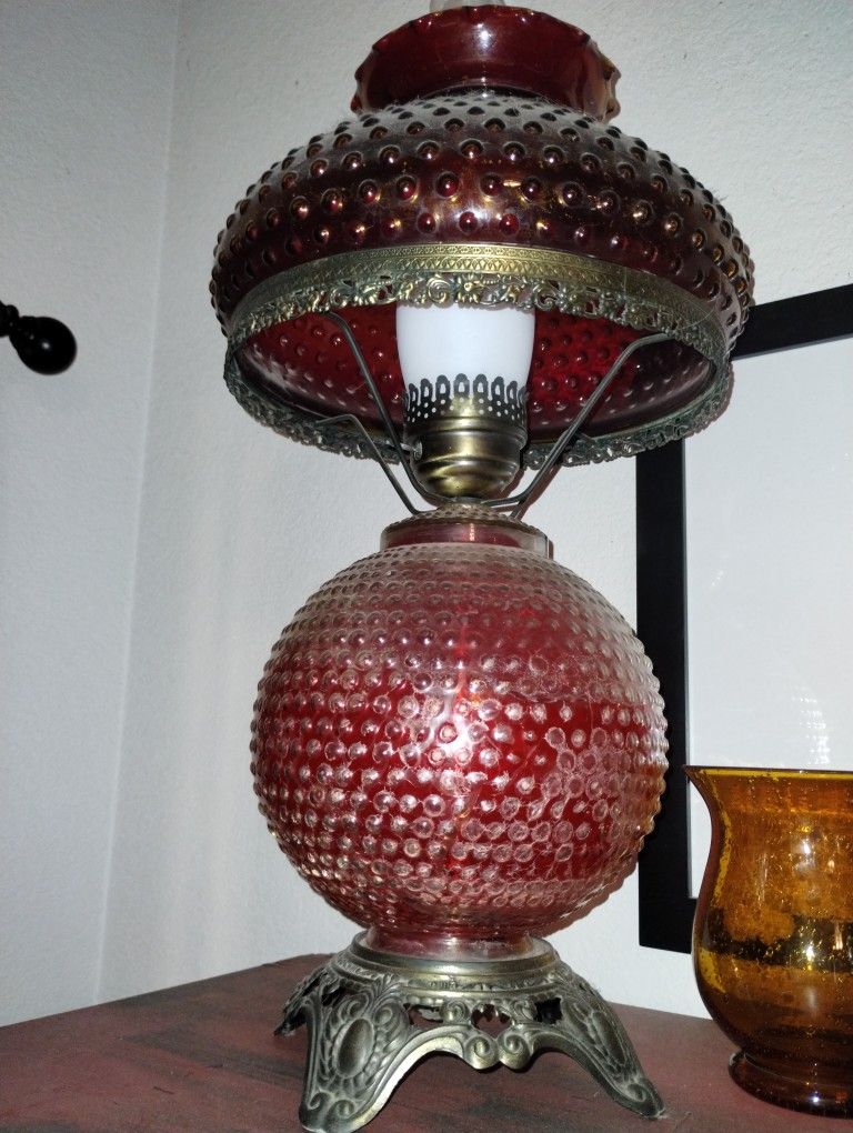 vintage red glass hobnail lamp with a brass base