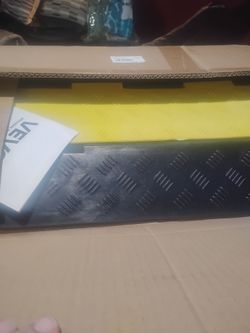 A black and yellow rubber cable protector ramp