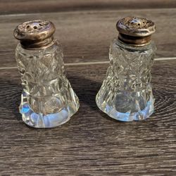 Antique glass salt and pepper shakers with sterling silver tops. See pictures for condition . See my other items available. 