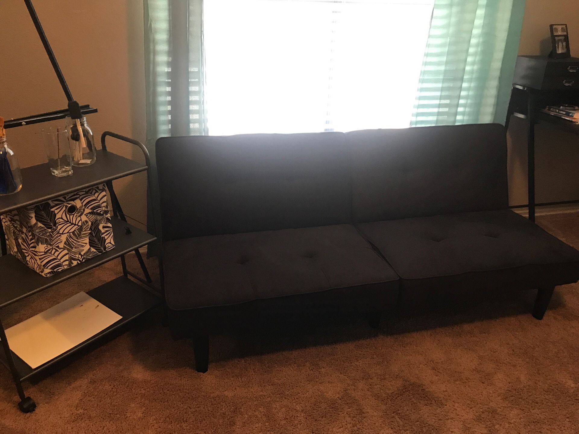 Black small futon sleeper lays out to a twin size or close to it