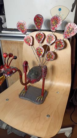 Swinging metal and stone peacock.