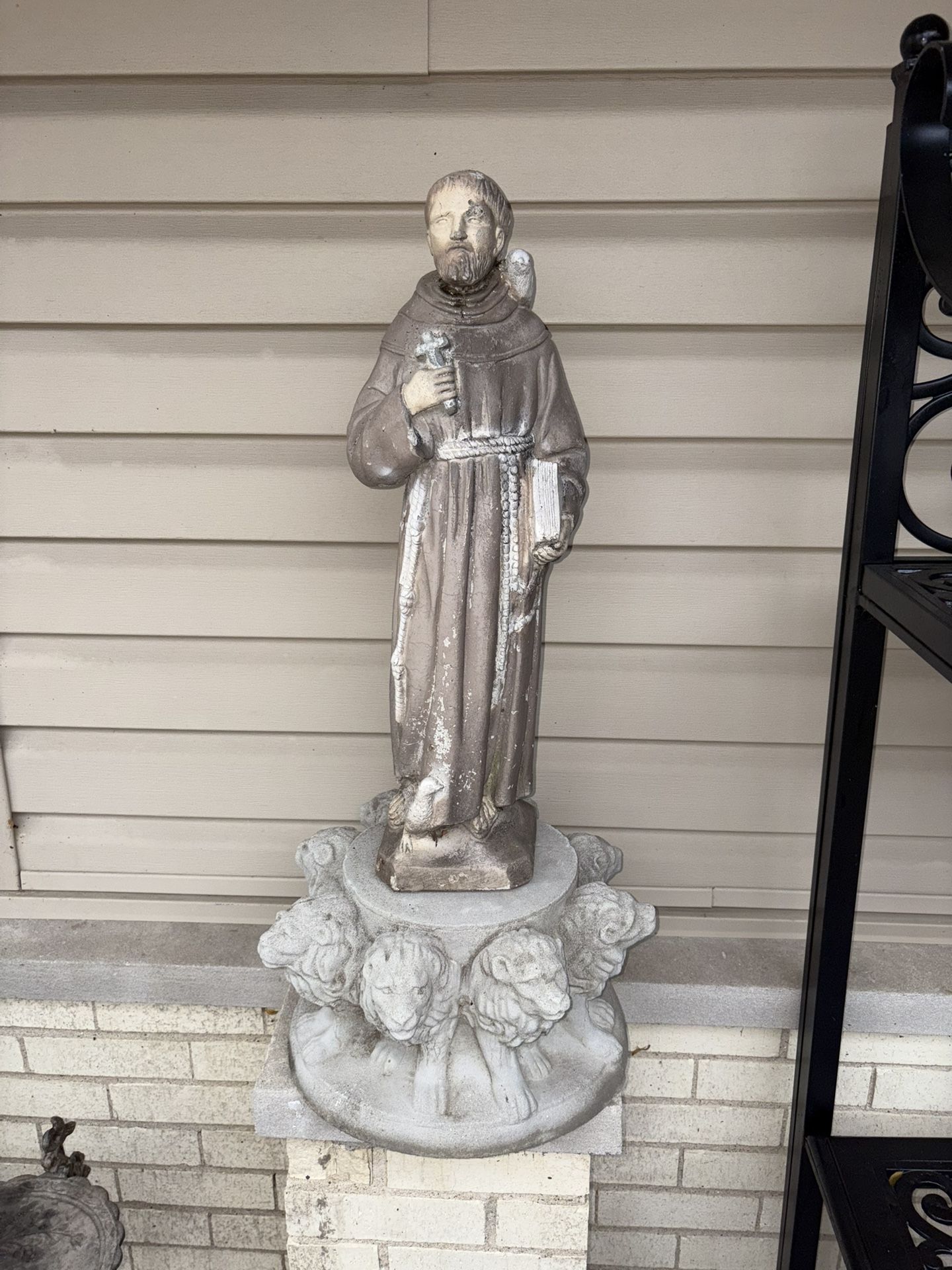 Garden statue of Saint Francis of Assisi. Patron Saint of animals & ecology. Surrounded by animals and sitting on top of a beautiful concrete base of 