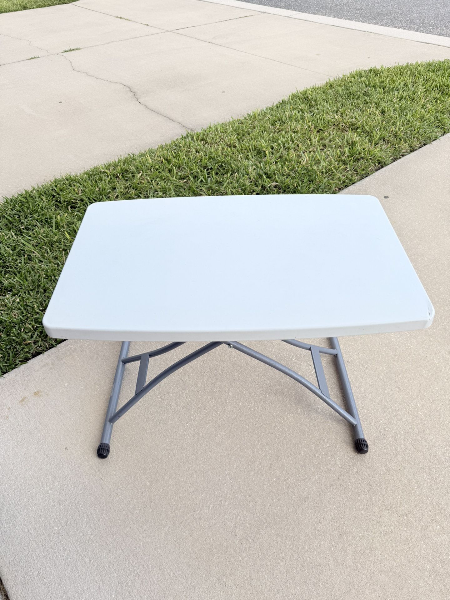 Selling a plastic table with adjustable height.