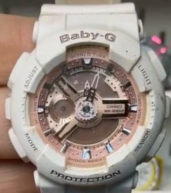 Casio Baby-G BA110-7A1 white and rose gold analog-digital watch featuring a gear-inspired mechanical dial and durable resin band