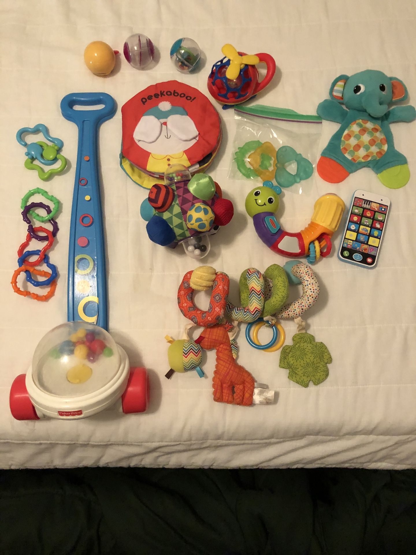 Assortment of baby toys, book, car seat toy and teethers