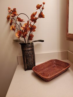 Tropical orchid plant in bamboo planter with rattan tray