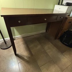 Brown wood desk with pullout, keyboard tray, and two drawers