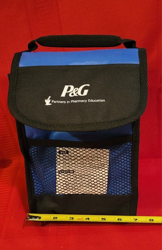 P&G (Procter & Gamble) insulated lunch bag/cooler. The bag has a handle and a mesh side pocket. 7"w×10"h×4"deep