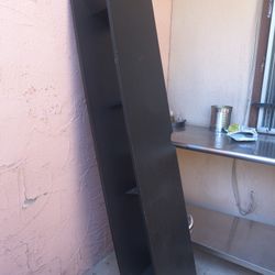 Mueble negro va pegado ala pared 