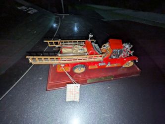 The item shown is the Franklin Mint 1922 Ahrens-Fox R-K-4 Pumper Fire Engine precision diecast model, presented on a wooden display base.
