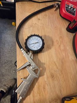 Pistol-grip tire inflator with an analog dial pressure gauge,
