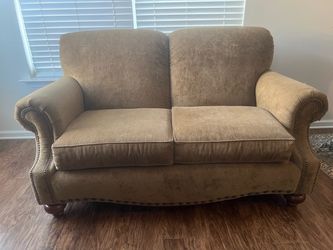 Basset love seat with nail head design and wooden feet.