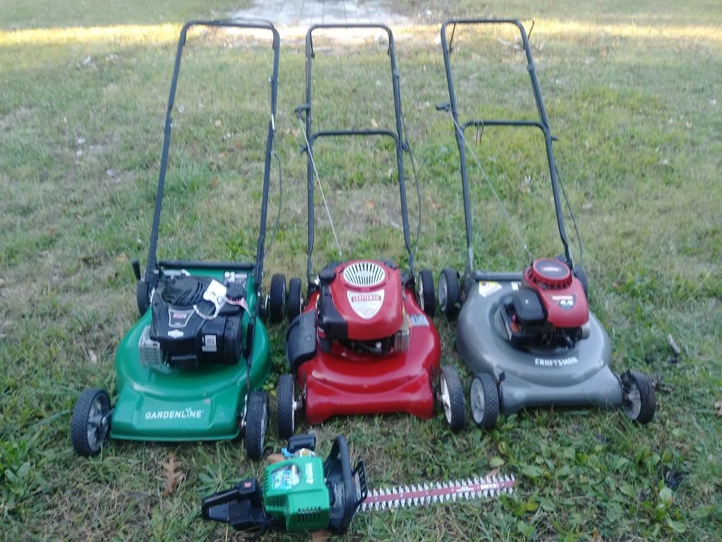 3 lawn mowers and a weed eater