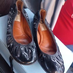 This is a pair of Lanvin patent-leather ballerina shoes in black. 