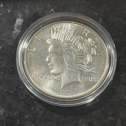 1 Troy oz .999 silver round with peace dollar design with a little bit of toning.