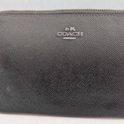 Coach Corner Zip Wristlet made of textured leather with silver-toned hardware. 
