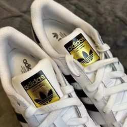 Adidas classic white shell toe shoes with the three-leaf clover logo