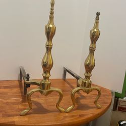 This is a pair of vintage brass and cast iron fireplace andirons with a baluster style and cabriole legs