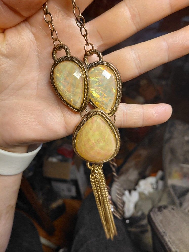 copper-toned fringe tassel chain necklace with three pear-shaped iridescent or opalescent-style pendants. 

