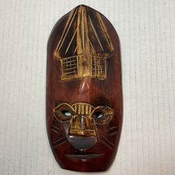 9 1/2” x 4 1/2” This image shows a handcrafted wooden mask featuring a stylized face with a structure on top