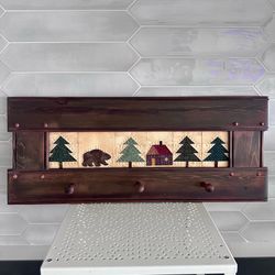 Vintage rustic wooden wall hanging coat/hat rack with quilted forest cabin design inset. 24” x 10” with 3 wooden pegs.