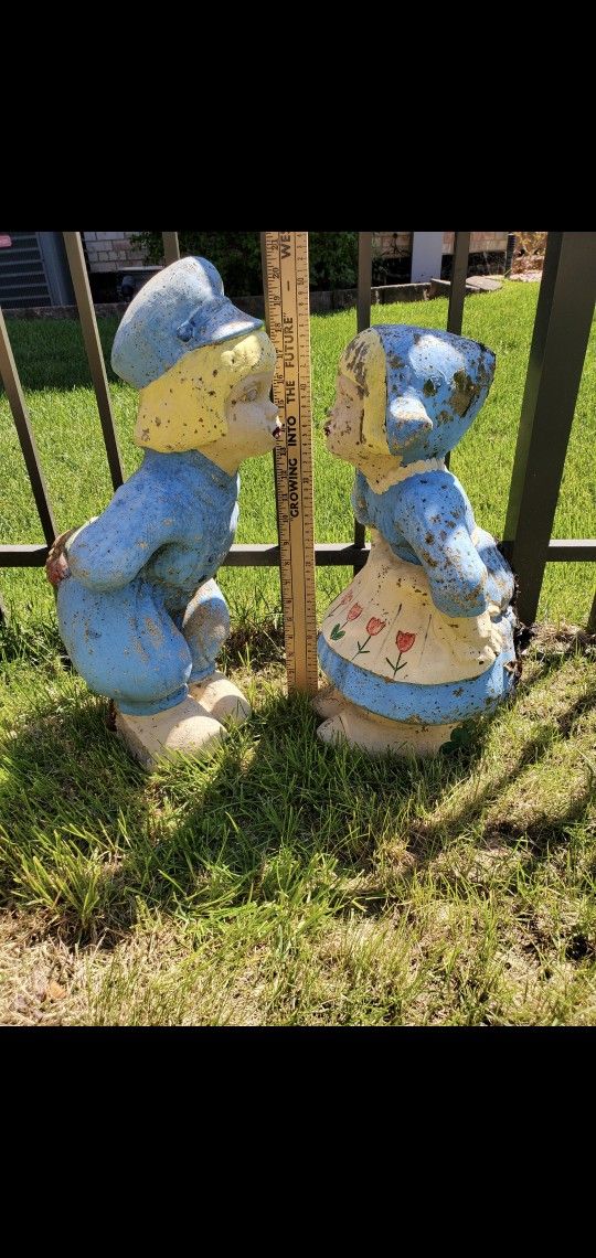 Vintage cement lawn garden decoration. Dutch boy & girl kissing
