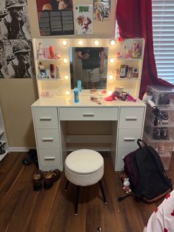 White vanity with mirror and stool.