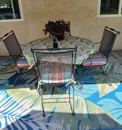 Outdoor wrought iron table set with 4 rocker chairs.
