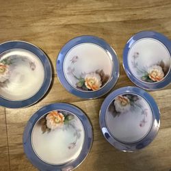 Vintage 5-piece porcelain set from Noritake, made in Japan, with blue rims, gold details and hand-painted floral motifs.