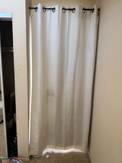 3 beige Ugg blackout curtains with black rods