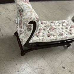 antique-style settee or loveseat with a carved wooden frame 