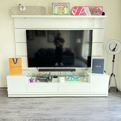 Modern white entertainment center with a 62-inch flat-screen TV.