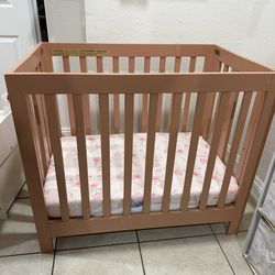 Mini crib with mattress and bed sheets