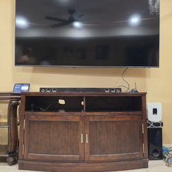 Dark wood TV stand with storage cabinets and shelves