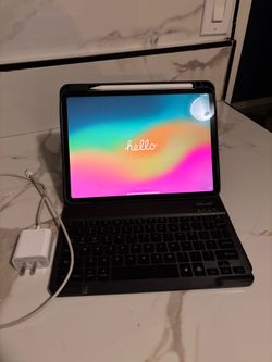 New iPad Pro M2 (4th Generation) with Apple Pencil and Keyboard; comes with a charger and a case.