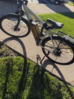 The image shows a silver Juiced Bikes CrossCurrent electric commuter bike (such as the CrossCurrent S or CrossCurrent X) equipped with a down-tube-mou
