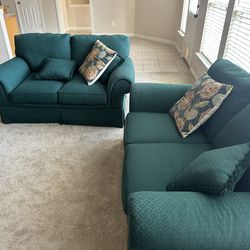 2 green loveseats (couches)