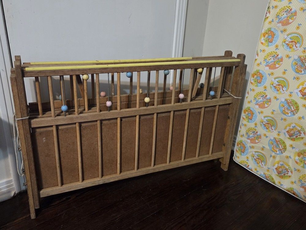 vintage wooden doll crib, also referred to as a port-a-crib or playpen for dolls.