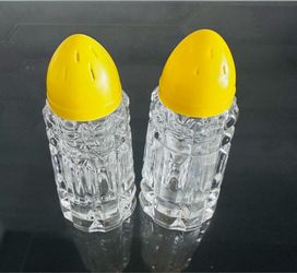 Vintage cut glass salt and pepper Shakers with yellow lids Heavier weight clear pattern glass. 3 1/2” tall