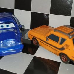 Rod "Torque" Redline, the dark blue American Muscle car, and Grim, the orange AMC Gremlin
