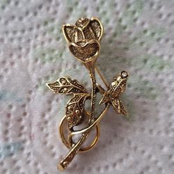 Vintage gold-tone rose brooch featuring crystal or rhinestone accents