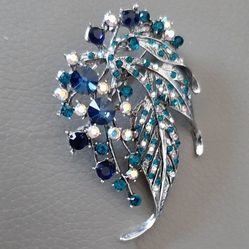 Silver tone brooch with green and blue stones.