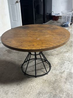 Round wooden dining room table with metal base