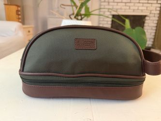 This is an Original Penguin olive green and brown trim travel/toiletry kit bag featuring textured canvas and faux leather accents.If you'd like, I can