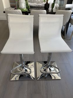 Two white adjustable stools