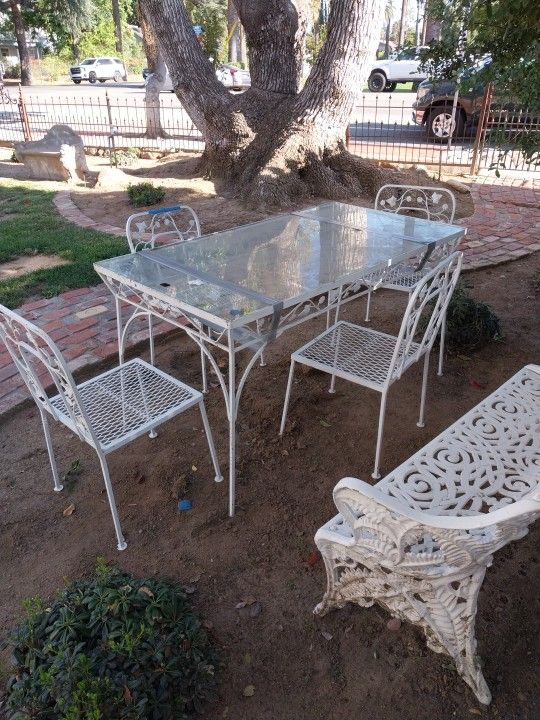 Antique Iron Garden or patio set 4 chairs and a glass top table.