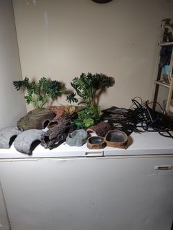 Large lot of reptile decorations, food bowls, and heating pads