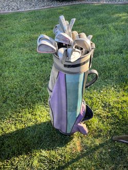 Lot of 13 mixed golf club irons in bag.